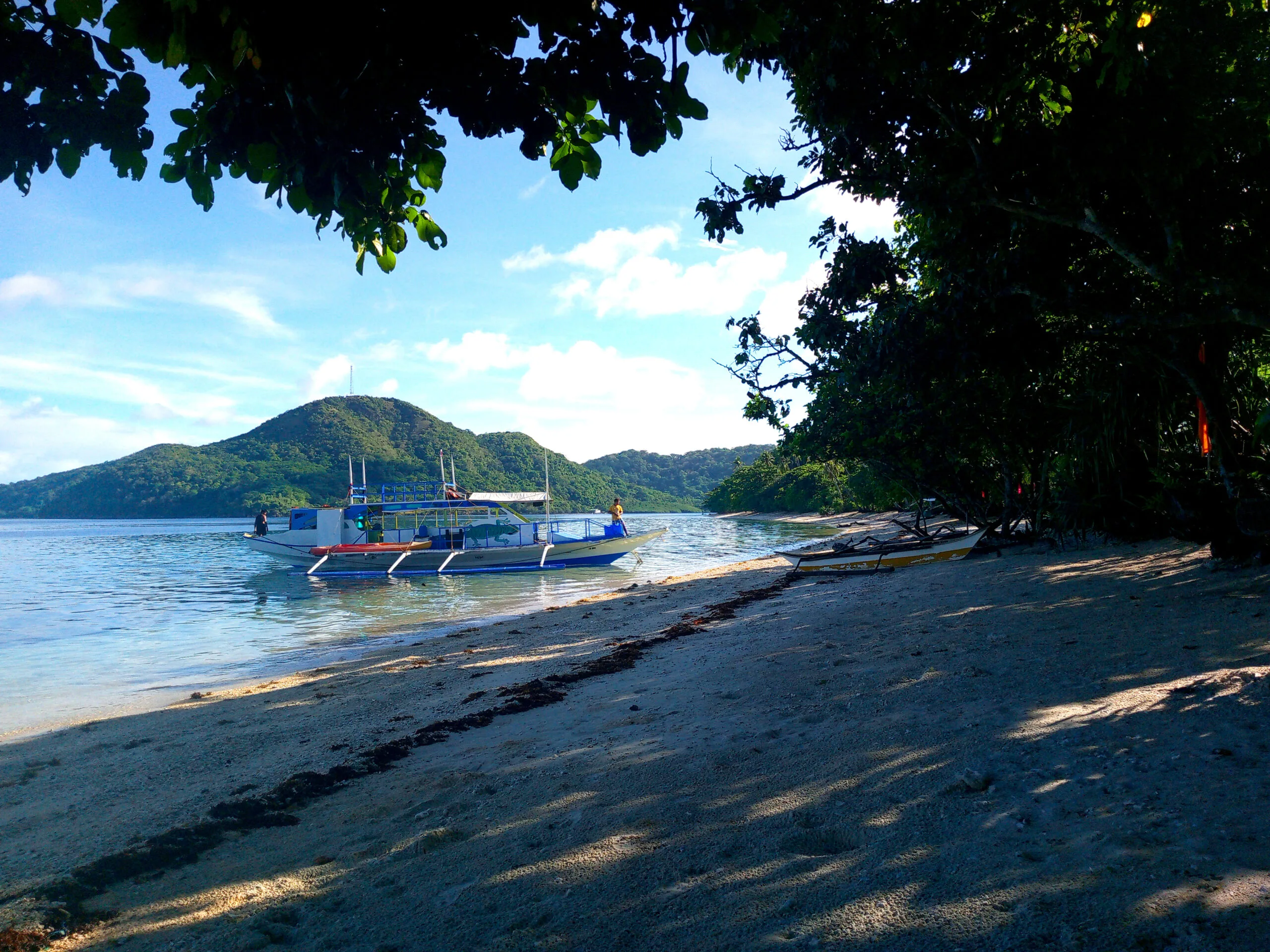 Tiki Expedition Tours 12 A solitary boat parked on a pristine beach with a picturesque view of a tropical paradise.