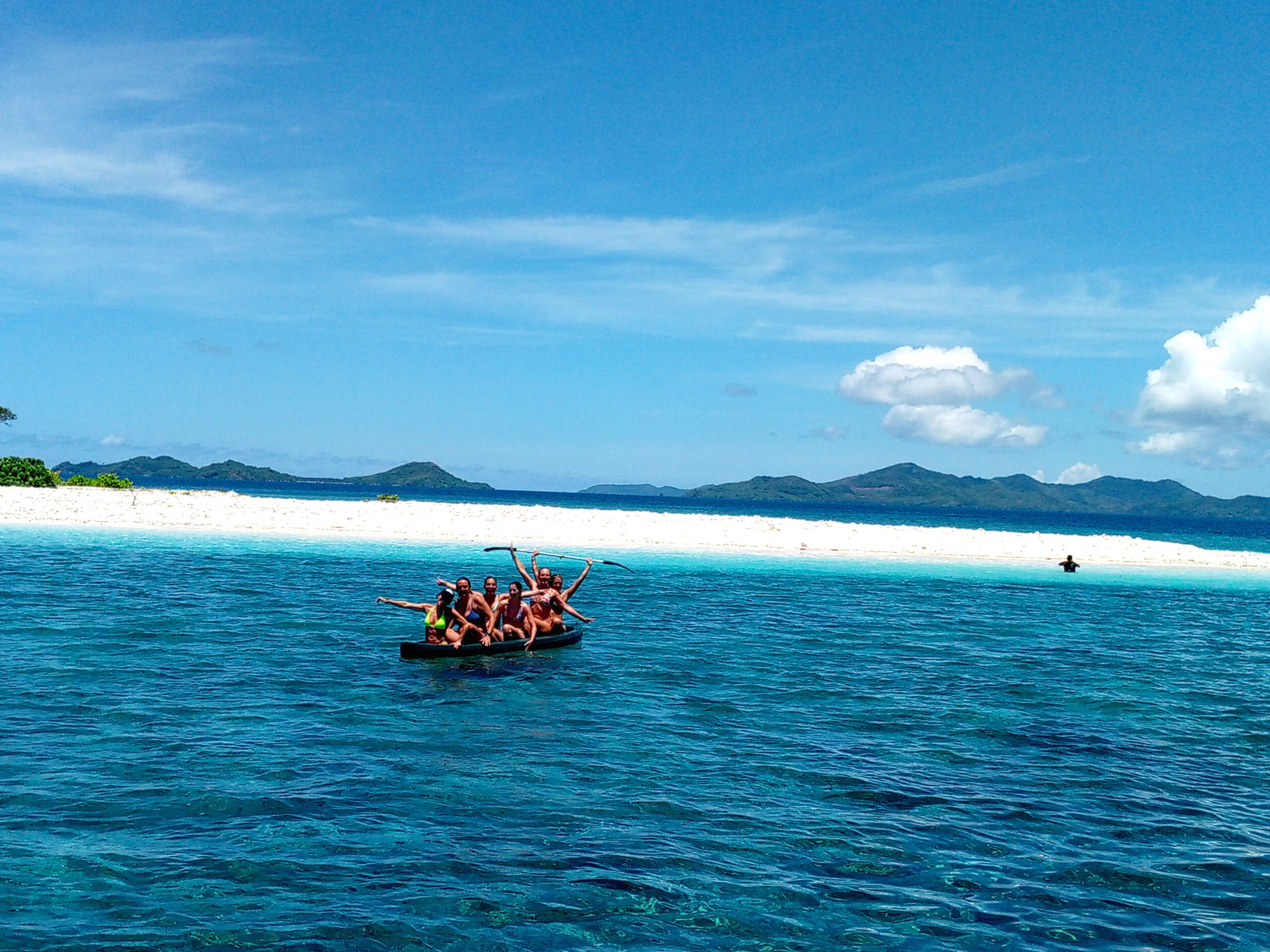 Tiki Expedition Tours 11 Group of friends enjoying a beach in El Nido, Coron, with white sands and crystal-clear waters.