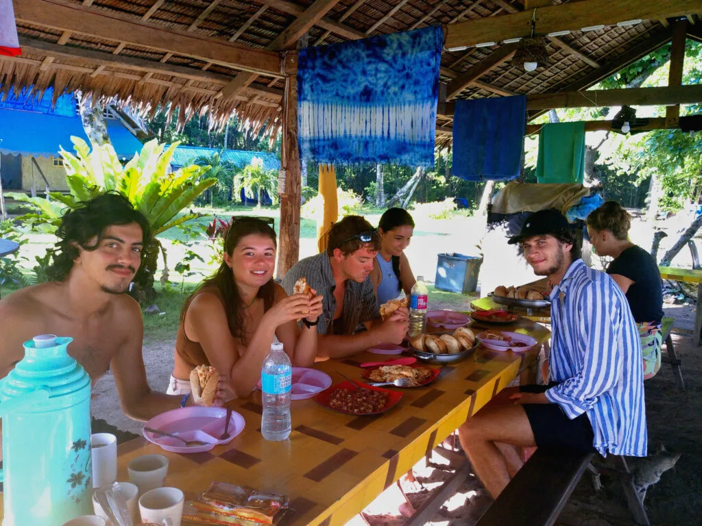 Tiki Expedition Tours 5 Group of people enjoying dinner during a tour in El Nido, Philippines, surrounded by beautiful scenery.