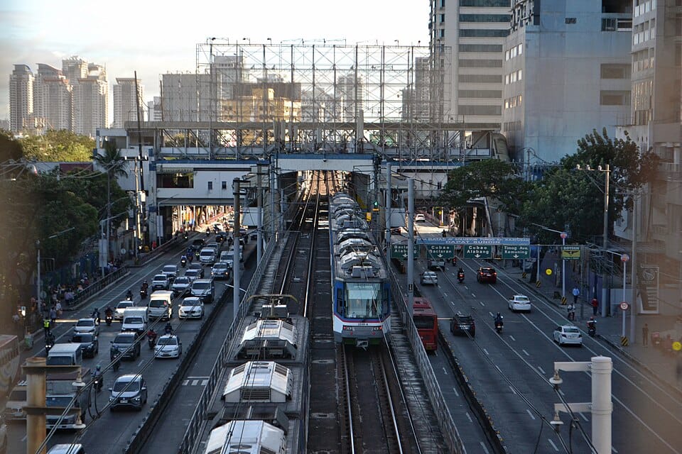 The Ultimate Travel Guide To The Philippines: What's not to be excited about? 3 MRT-3 train at Kamuning Station in Quezon City, showing daily urban commute and traffic along EDSA in Metro Manila, Philippines.